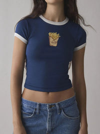 Person wearing a blue t-shirt with a graphic design on a plain background