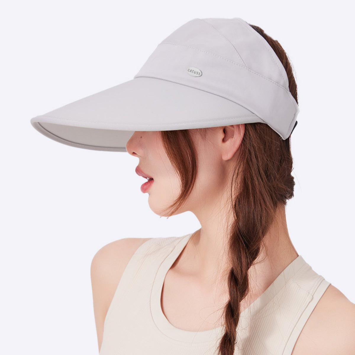 Woman wearing a gray visor on a white background