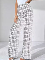 Black and white checkered pants worn by a person on a light gray background