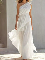 A woman walking beside a building wearing a white One-Shoulder Ruffled Chiffon Maxi Dress