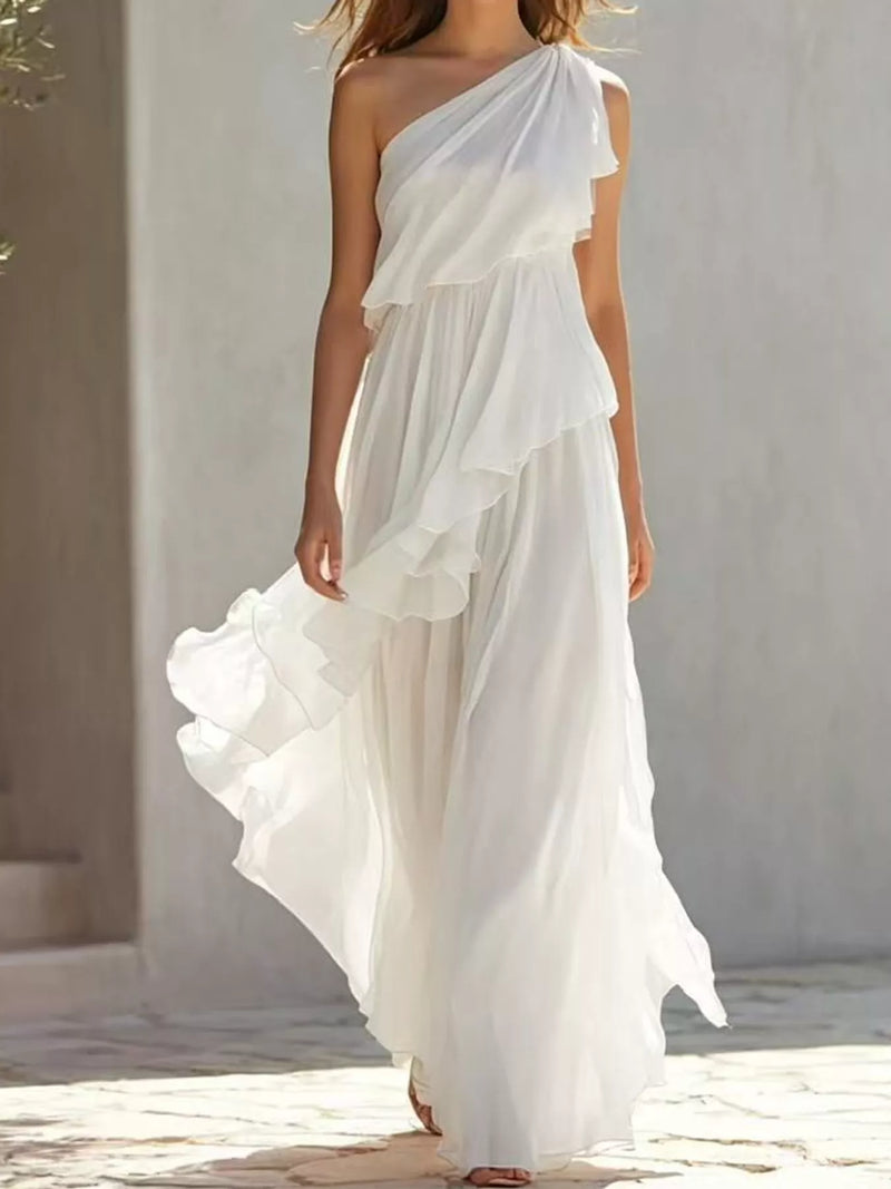 A woman walking beside a building wearing a white One-Shoulder Ruffled Chiffon Maxi Dress