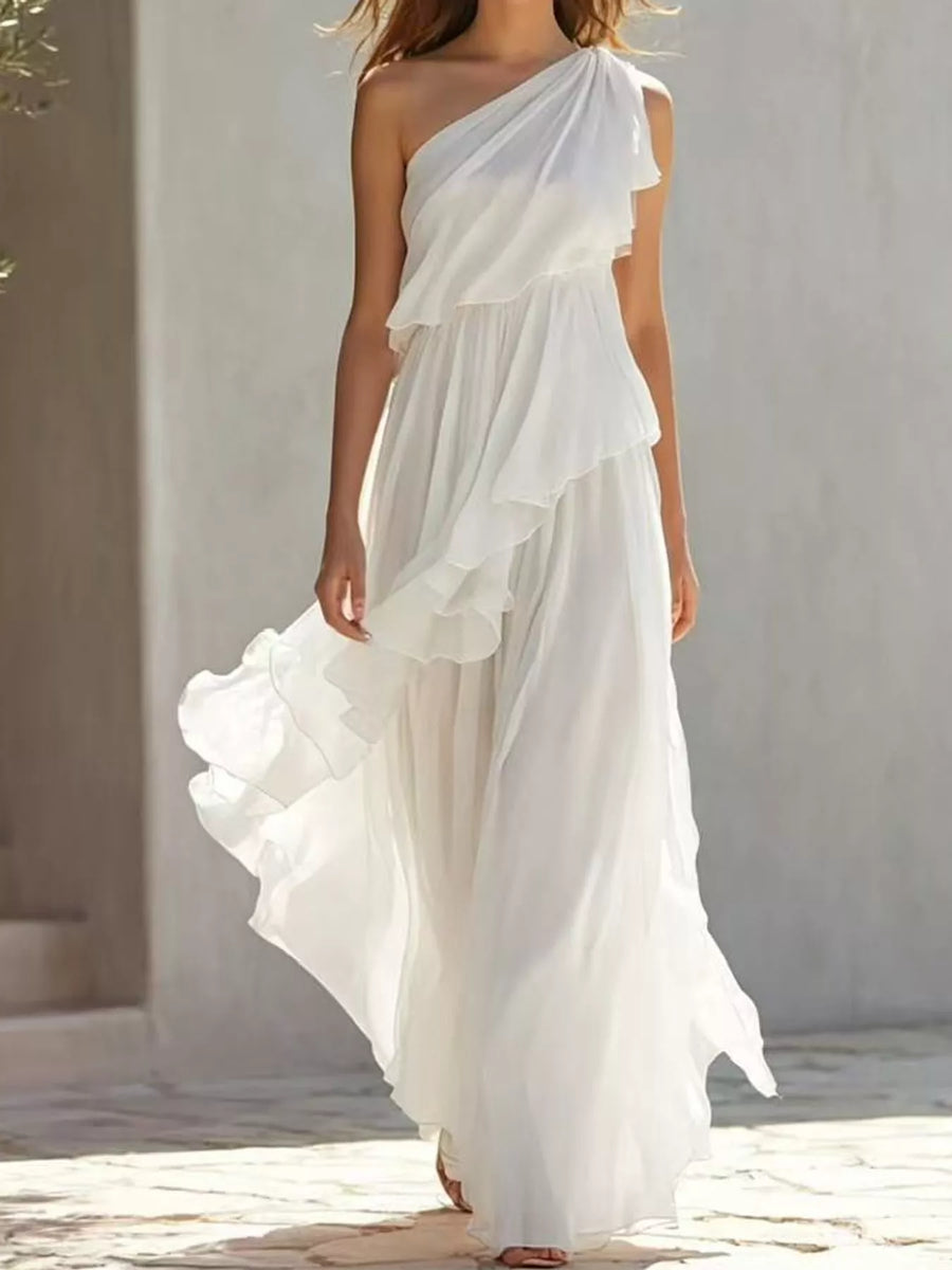 A woman walking beside a building wearing a white One-Shoulder Ruffled Chiffon Maxi Dress