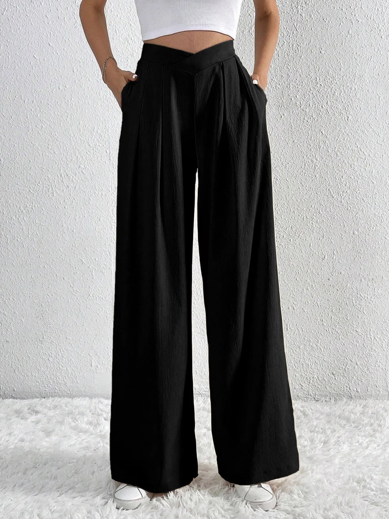 Black wide-leg pants worn by a person on a white background