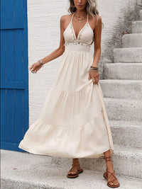 Woman in a white dress standing on steps with a blue door in the background