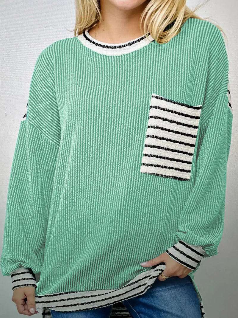 Green sweater with striped pocket and cuffs worn by a person