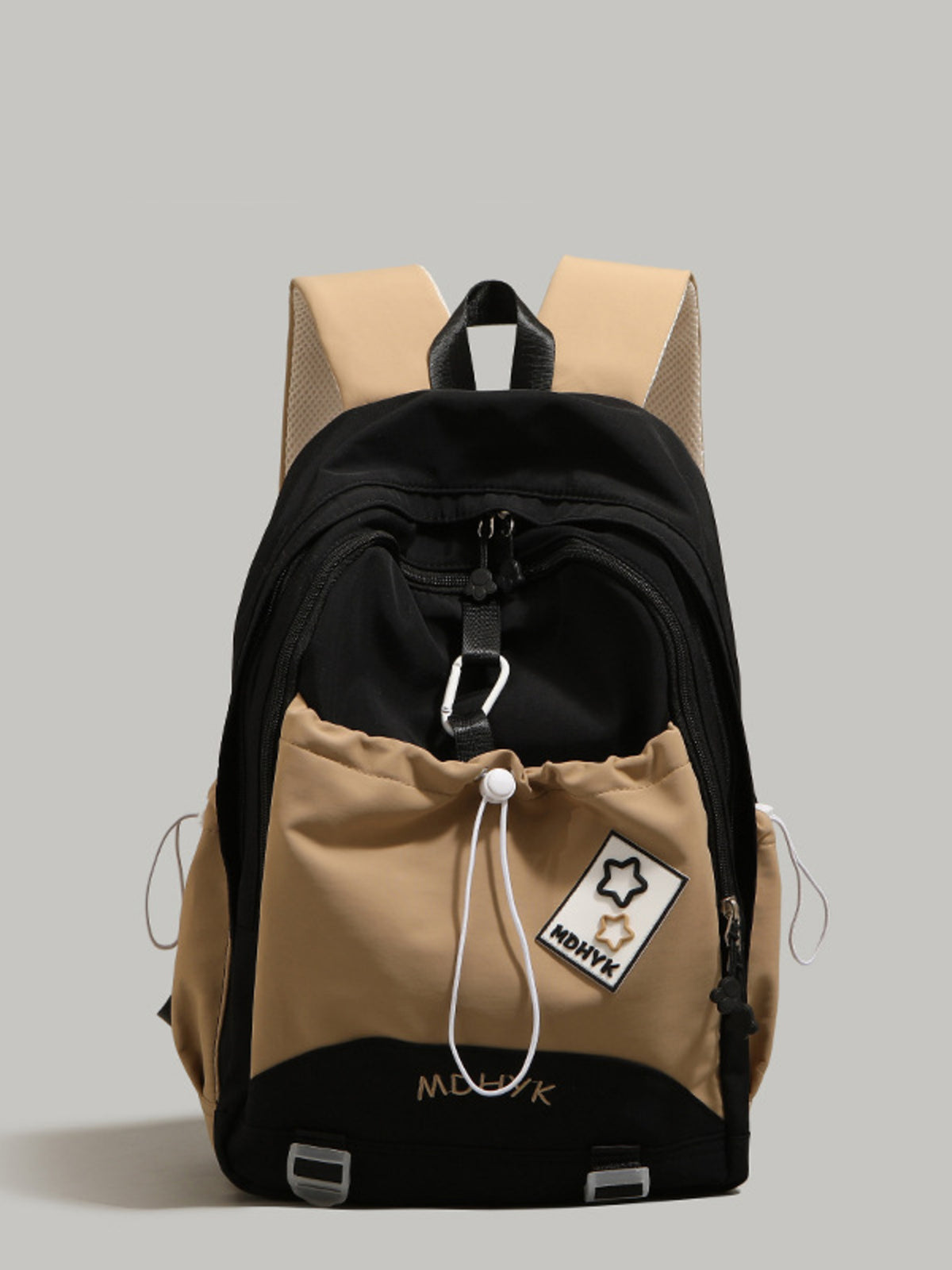 Two-tone backpack with black and beige sections on a gray background
