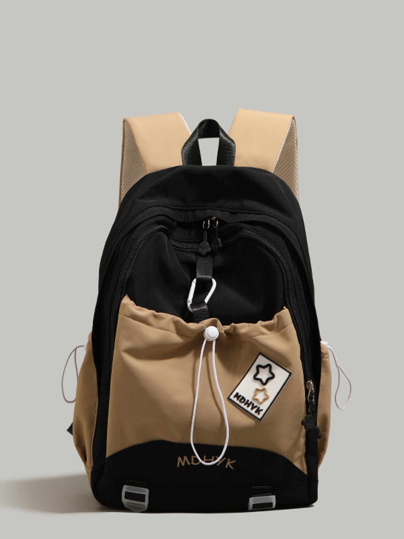 Two-tone backpack with black and beige sections on a gray background