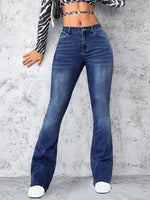 Person wearing blue jeans against a gray concrete wall