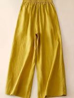 Mustard yellow pants on a light beige background