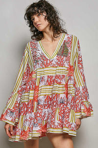 Woman wearing a colorful patterned dress against a plain background