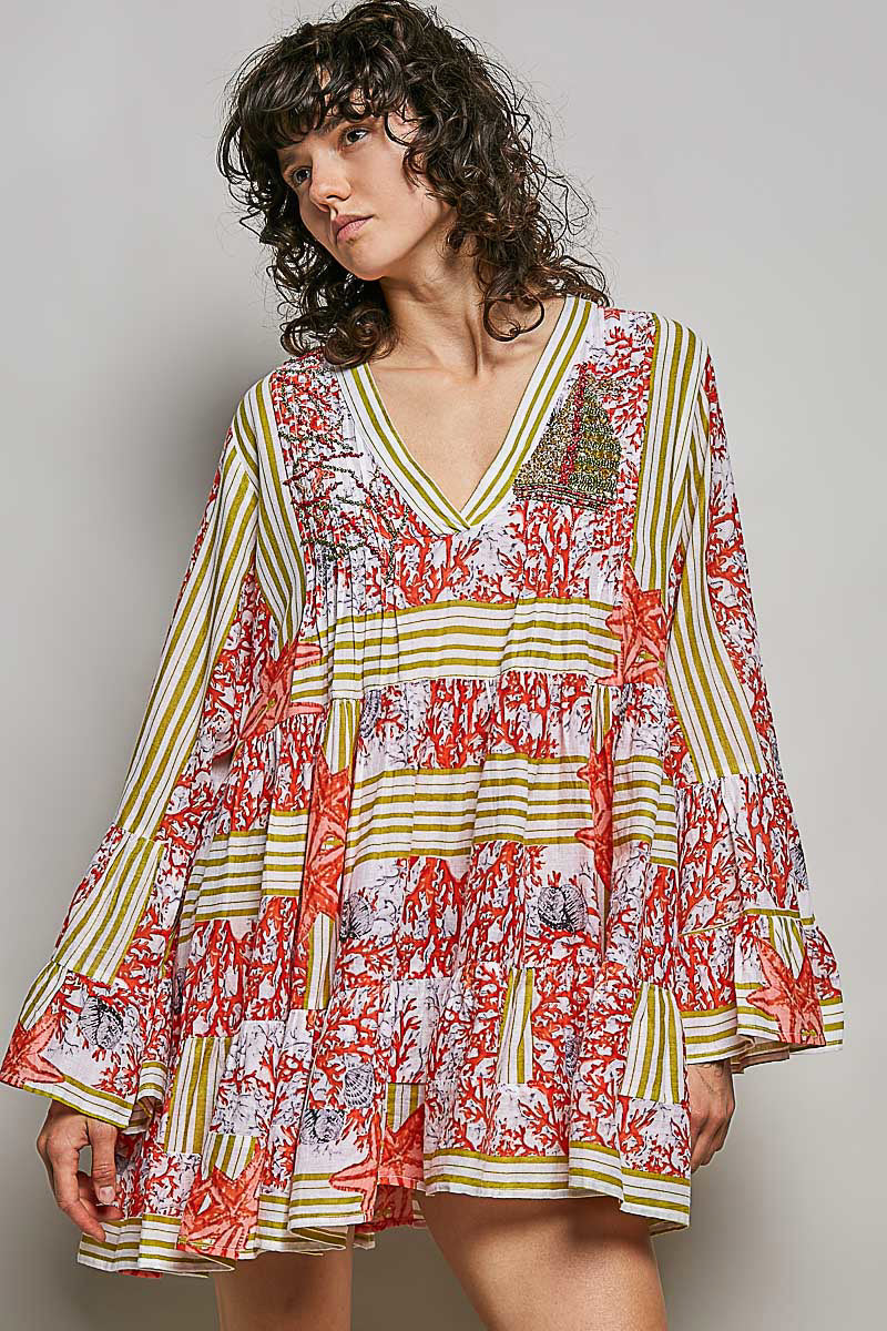 Woman wearing a colorful patterned dress against a plain background