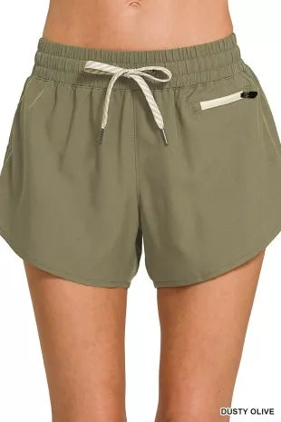 Olive green shorts with a drawstring on a white background