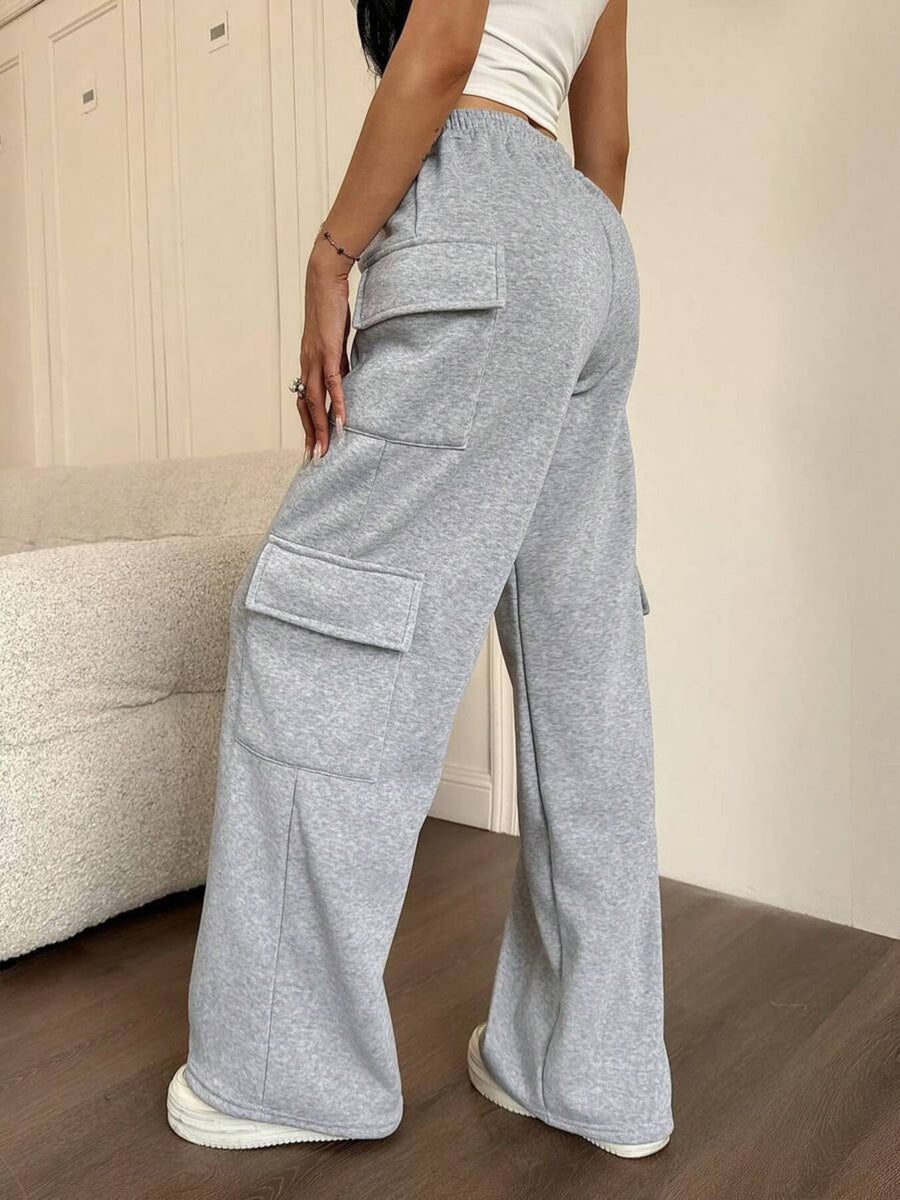 Person wearing gray cargo pants in a room with a beige sofa.