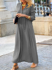 Woman wearing a long gray dress in an urban setting