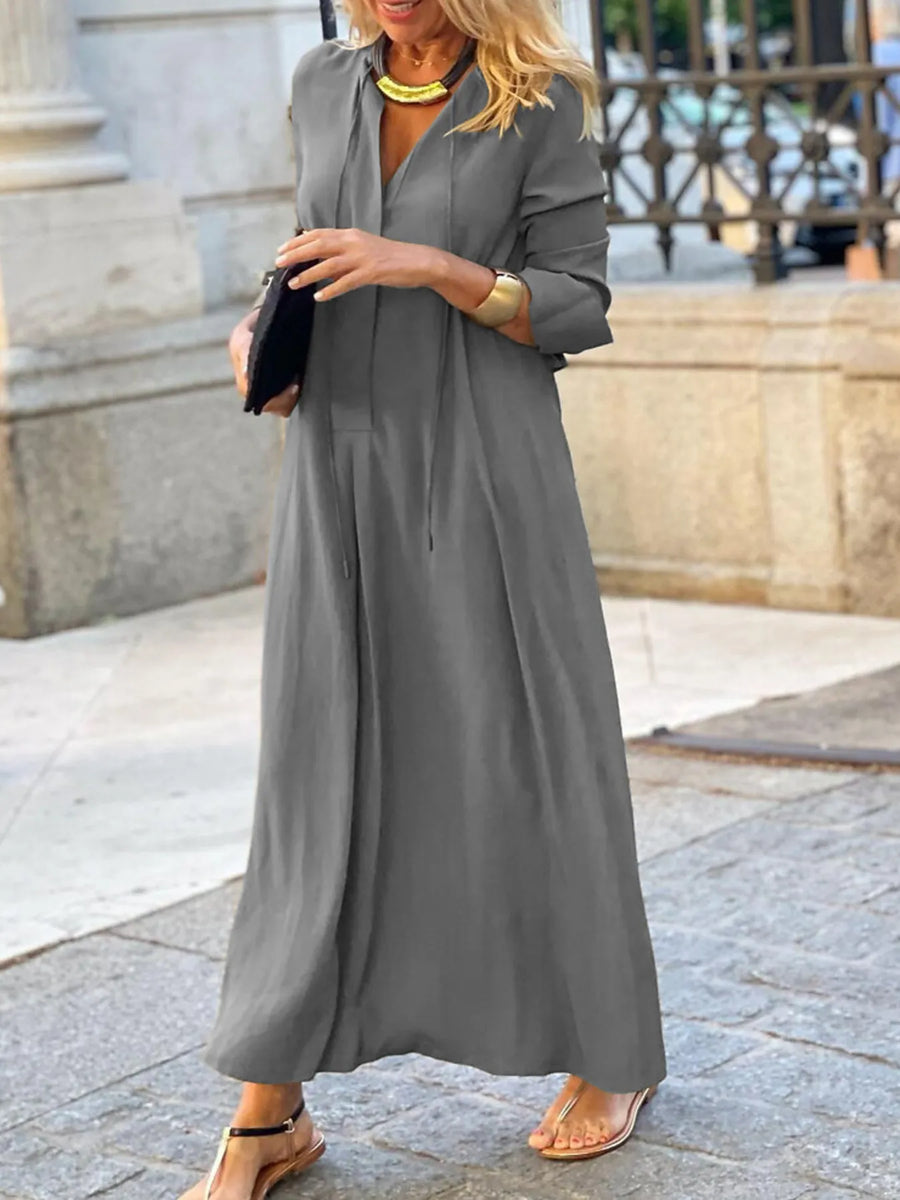 Woman wearing a long gray dress in an urban setting