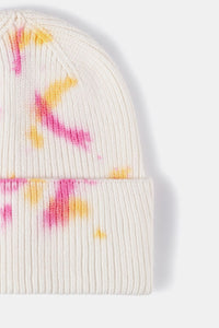 White beanie with pink and yellow tie-dye pattern on a white background