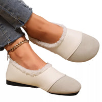 White shoes with black soles worn by a person on a white background