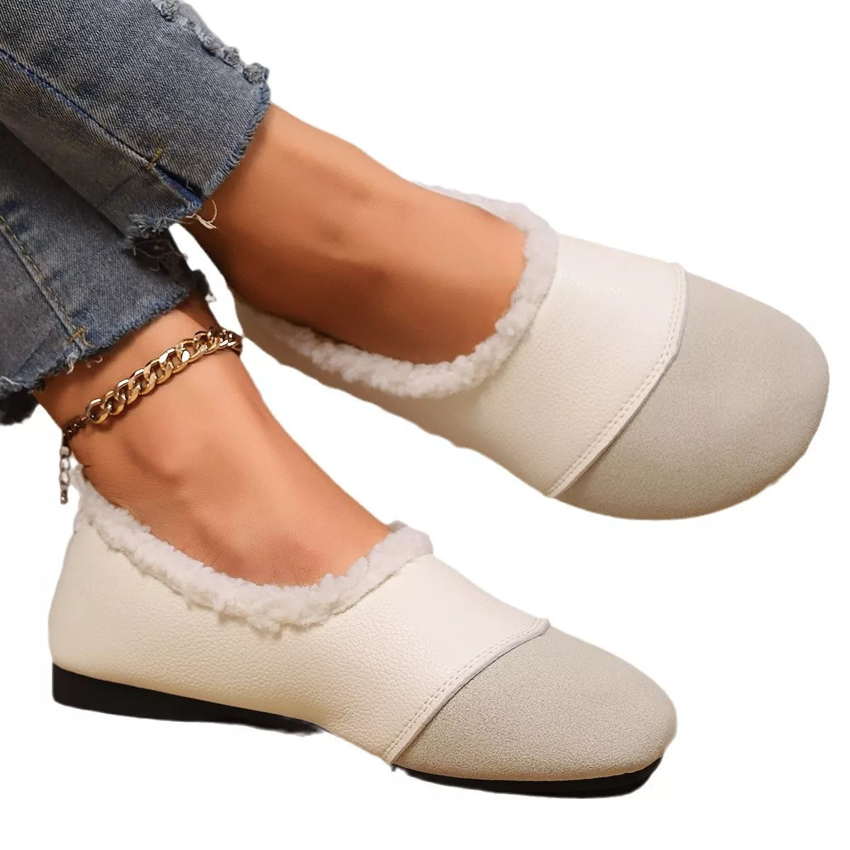 White shoes with black soles worn by a person on a white background