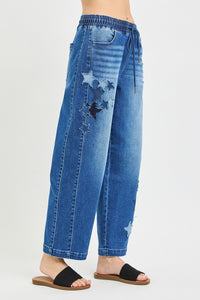 Blue jeans with star patches on a white background