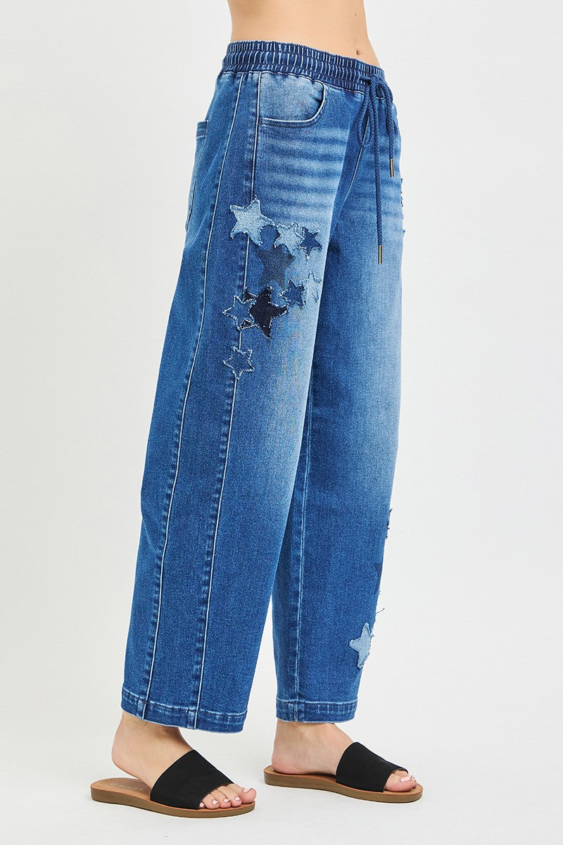 Blue jeans with star patches on a white background