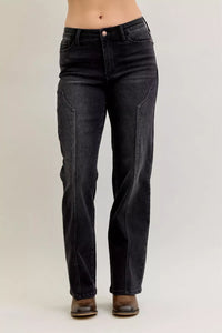 Black jeans worn by a person on a plain background