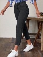 Person wearing black pants and white sneakers in a casual setting