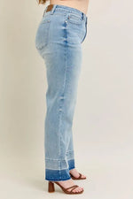 Light blue jeans worn by a person on a beige background