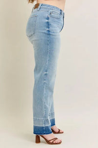 Light blue jeans worn by a person on a beige background