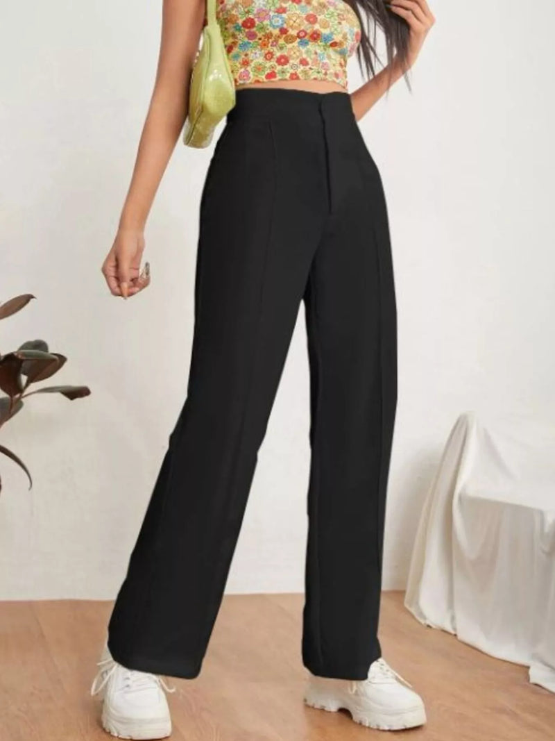 Person wearing a floral crop top and black wide-leg pants with a white background