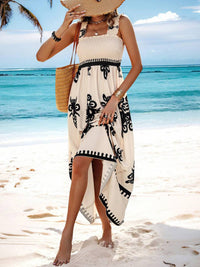 Woman in a white dress with black patterns on a beach