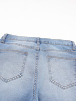 Close-up of light blue denim jeans on a white background