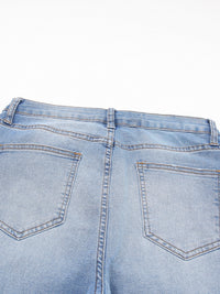 Close-up of light blue denim jeans on a white background
