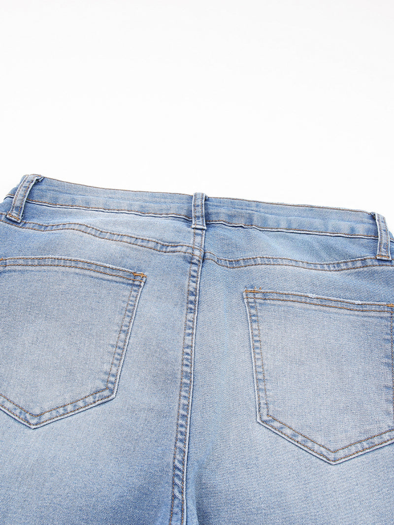 Close-up of light blue denim jeans on a white background