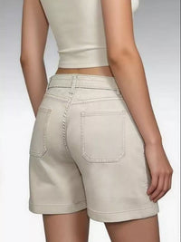 Beige shorts worn by a person on a plain background