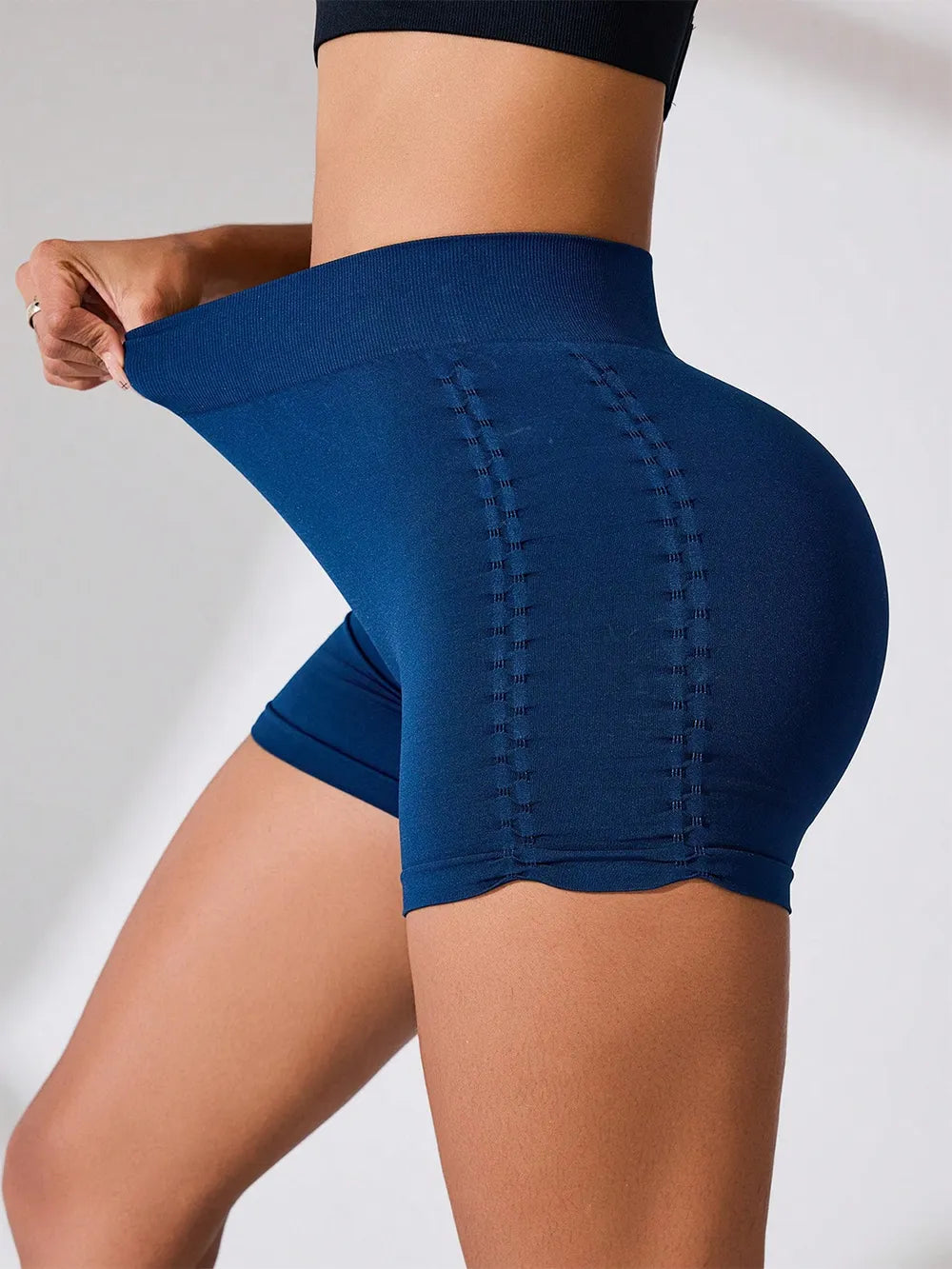 Blue athletic shorts worn by a person on a plain background