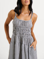 Woman wearing a black and white striped dress on a plain background