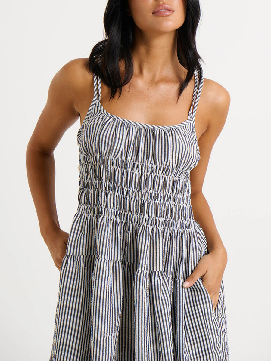 Woman wearing a black and white striped dress on a plain background