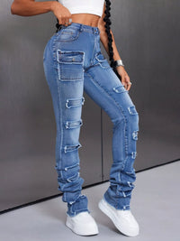 Person wearing high-waisted, distressed blue jeans with a gray background