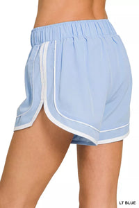 Light blue athletic shorts with white trim on a white background