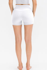 Person wearing white high-waisted shorts on a plain background