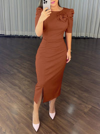 Woman wearing a brown dress with a floral detail in an indoor setting.