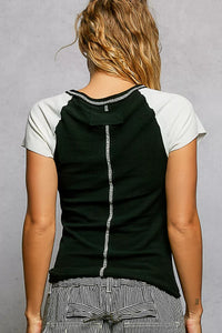 Person wearing a black and white sleeveless top with a gray background