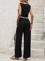 Person wearing a black jumpsuit with white trim on a staircase.