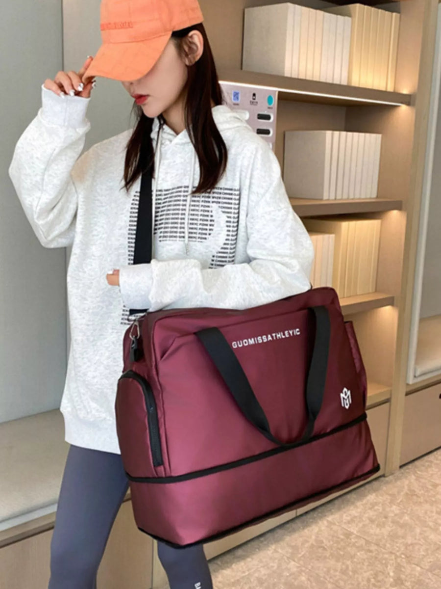 Person holding a maroon bag with a brand logo in an indoor setting