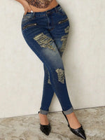 Distressed blue jeans worn by a person on a plain background