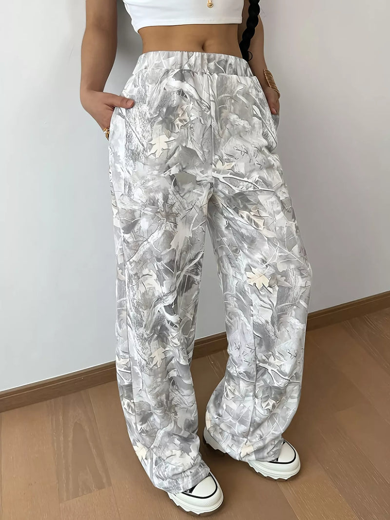 Person wearing white floral pants with a plain background