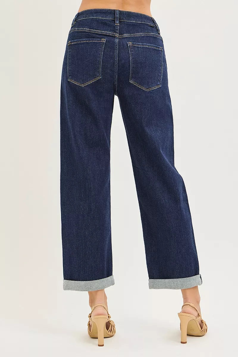 Dark blue jeans with a cuffed hem on a white background