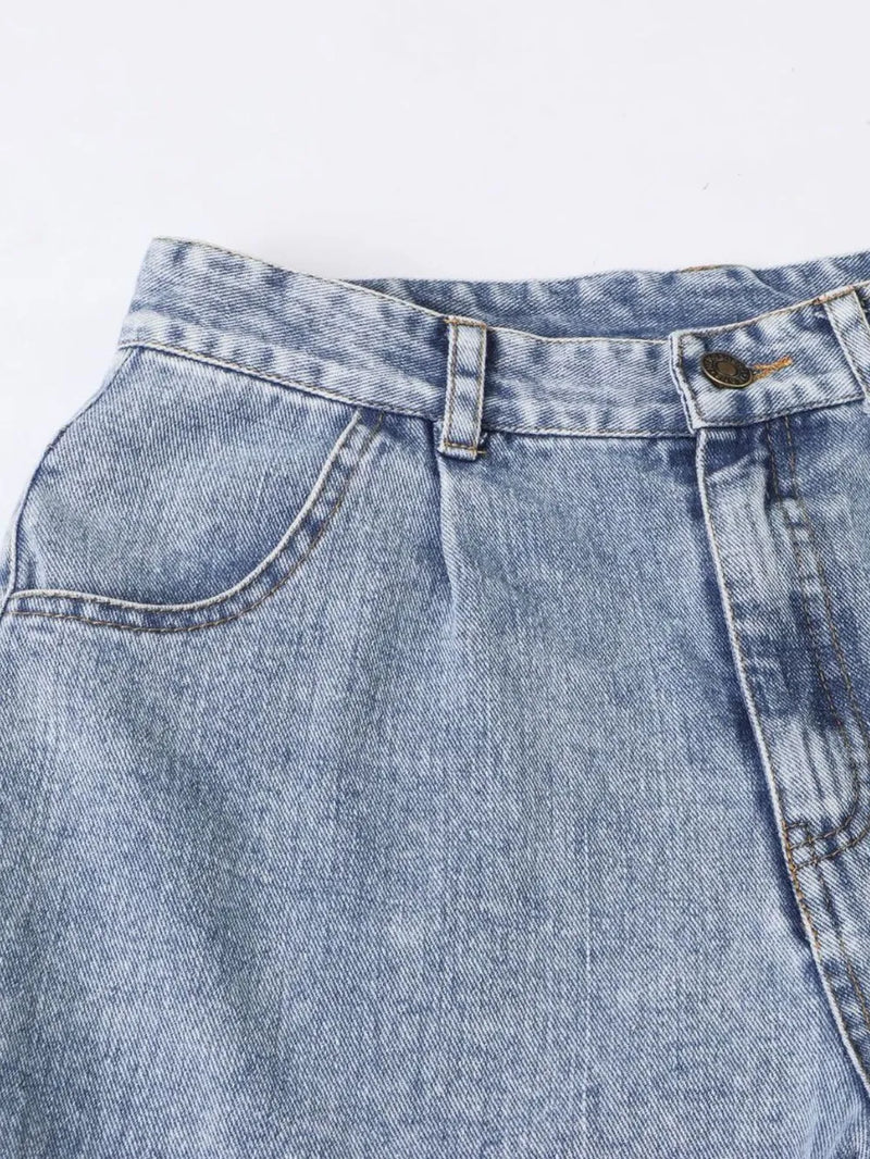 Close-up of a blue denim pocket with stitching details on a light gray background