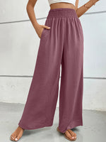 Mauve wide-leg pants worn by a person on a light gray background