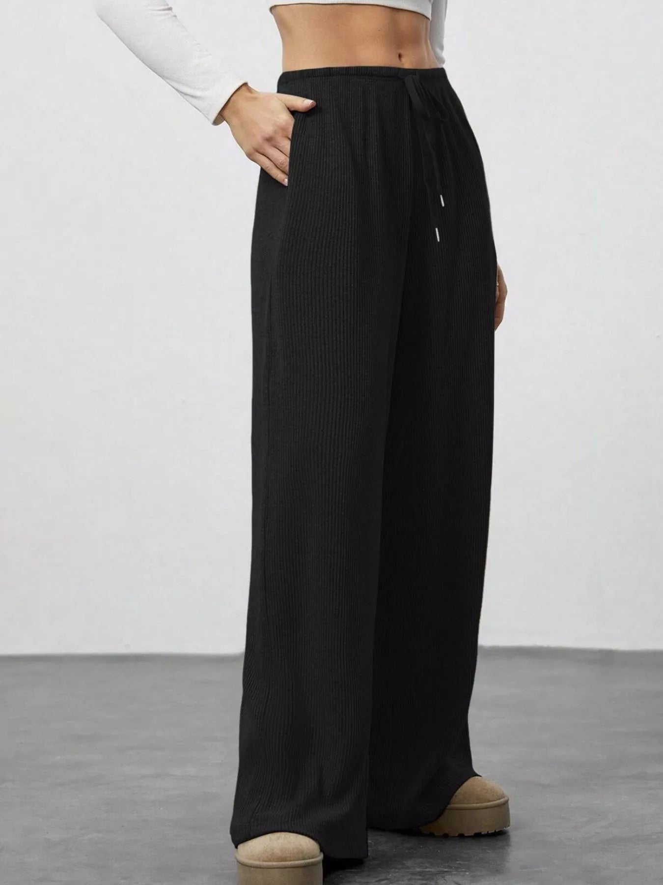 Black wide-leg pants worn by a person on a plain background